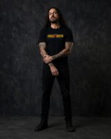 Homem metaleiro de corpo inteiro com T-shirt preta oficial Força Bruta